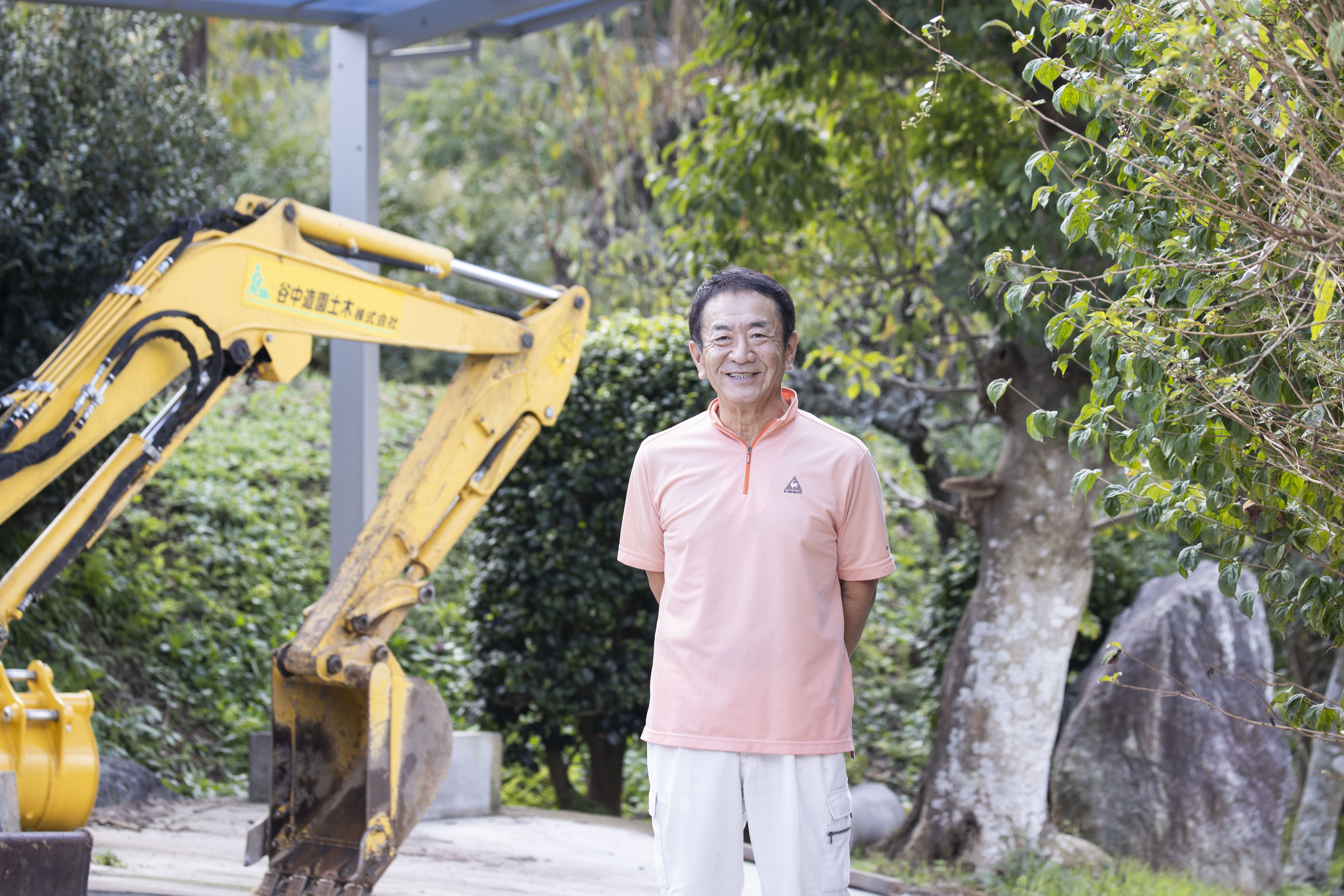 庭の緑を背景に立つ谷中造園土木の代表
